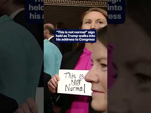 "This is not normal" sign held as Trump enters address to Congress