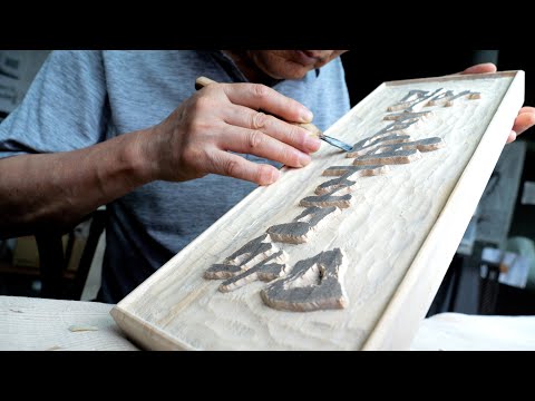 The process of an old Korean craftsman making a signboard out of solid wood.