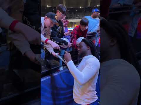 Shaboozey signing autographs for fans.